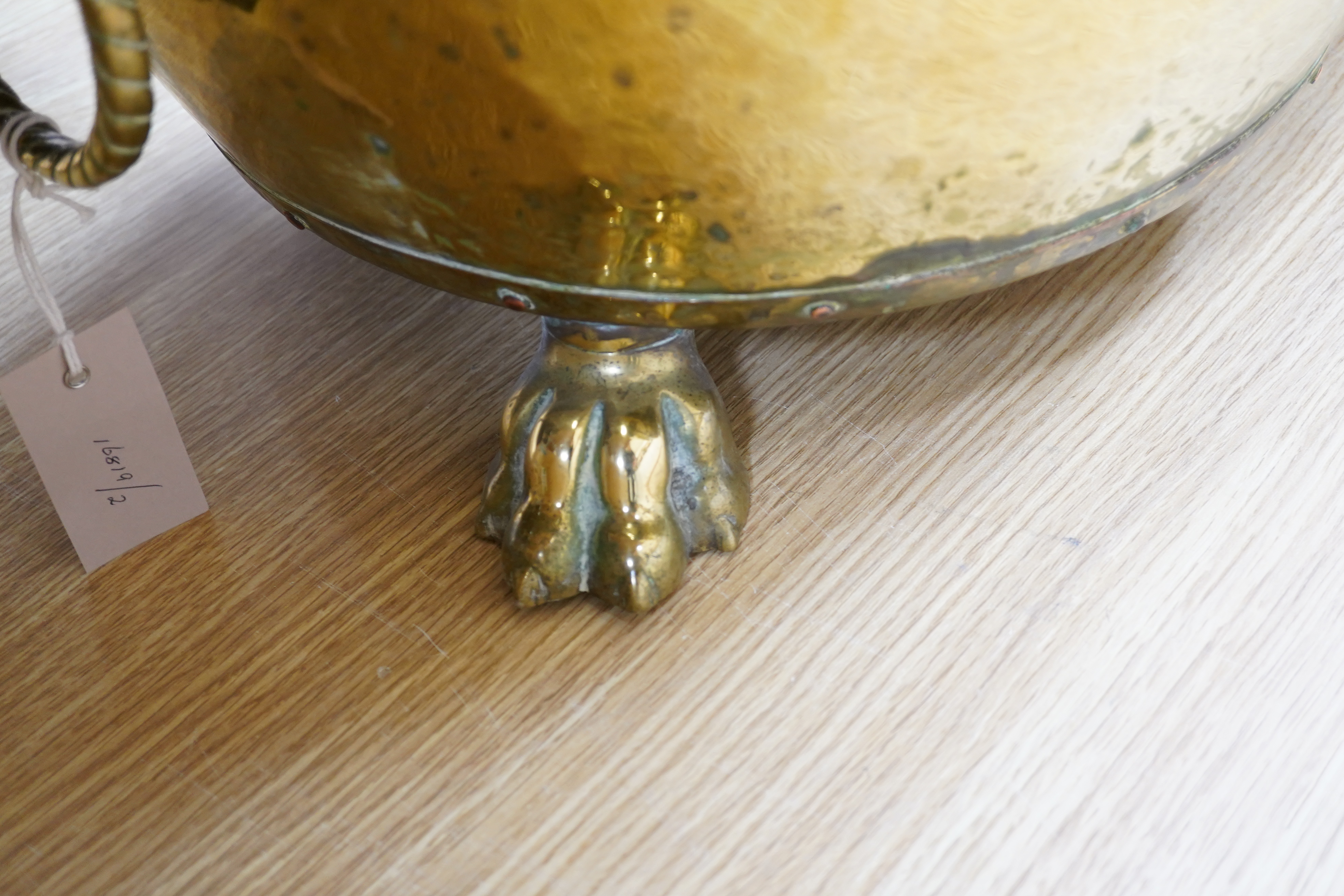 A large Victorian brass log bucket with lions head handles and paw feet, 50cm in diameter. Condition - fair to good